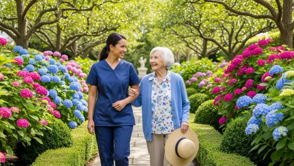 An EagleWings caregiver walks arm-in-arm with a senior client through a private Baltimore garden.